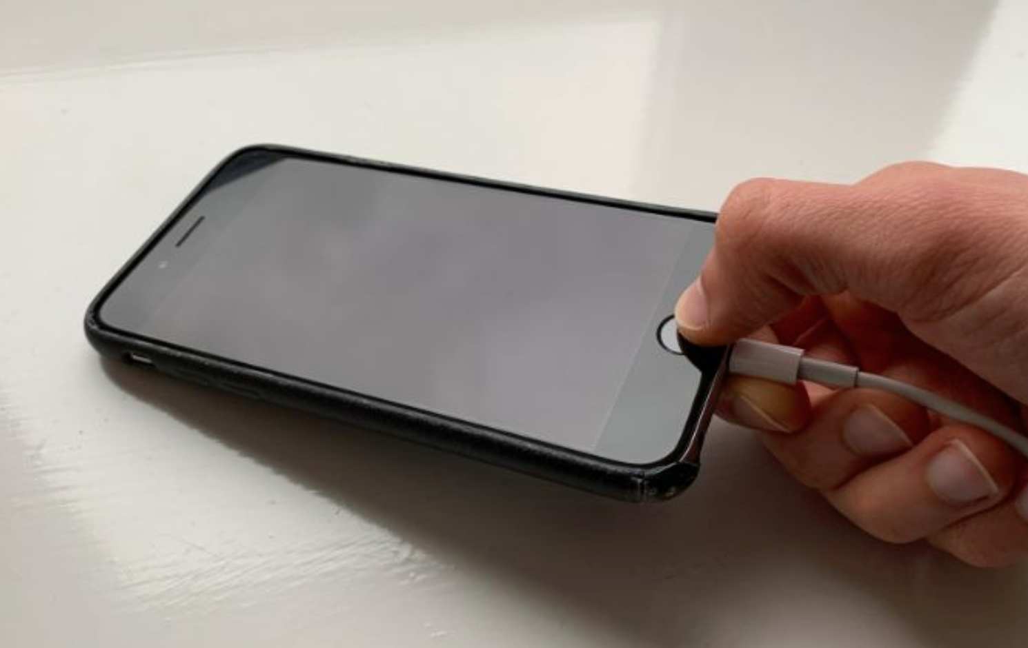 5. از شارژر آیفون برای فشردن دکمه هوم استفاده کنید